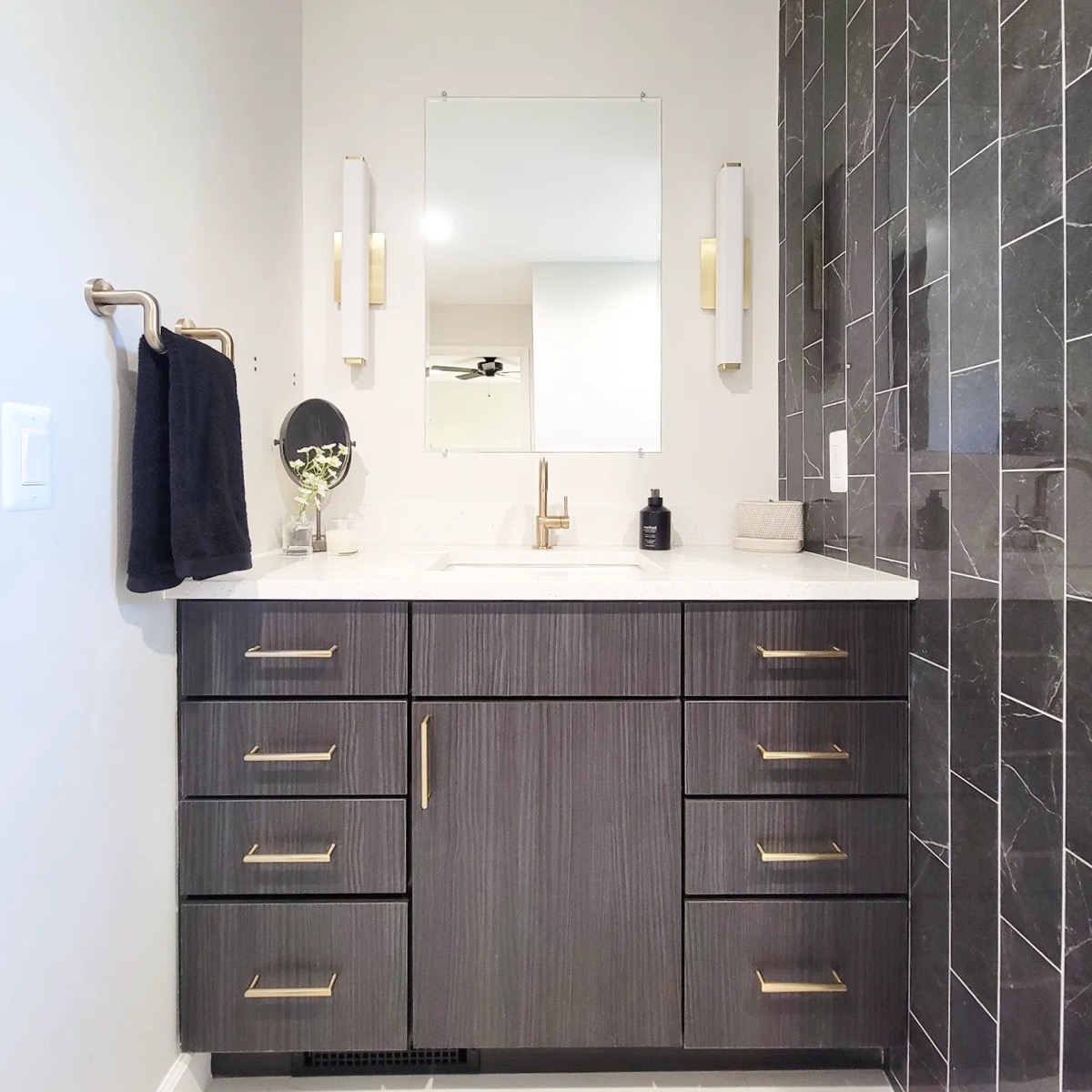Modern vanity with black marble chevron tile and brass pulls