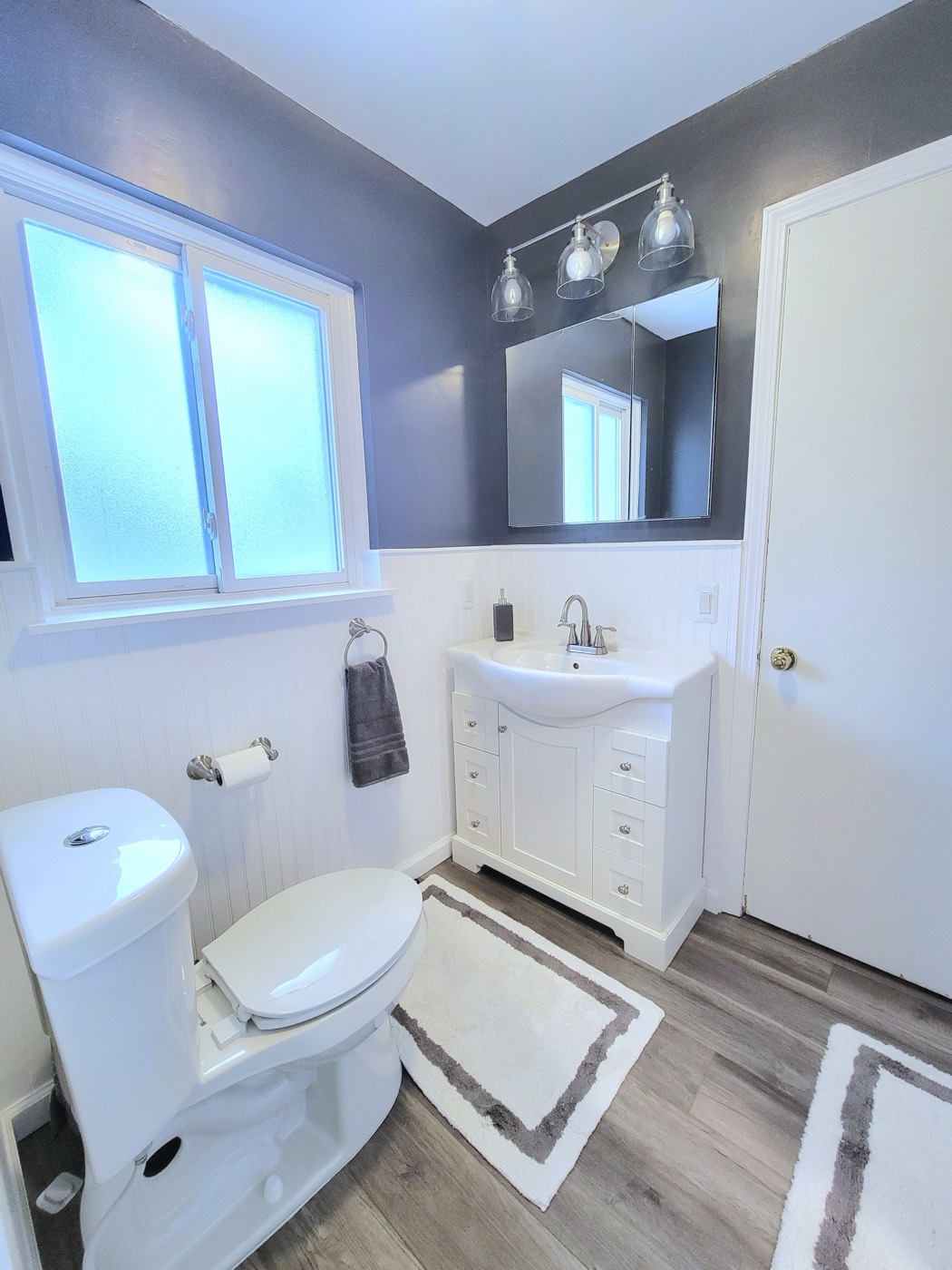 Charcoal walls with white wainscoting bathroom