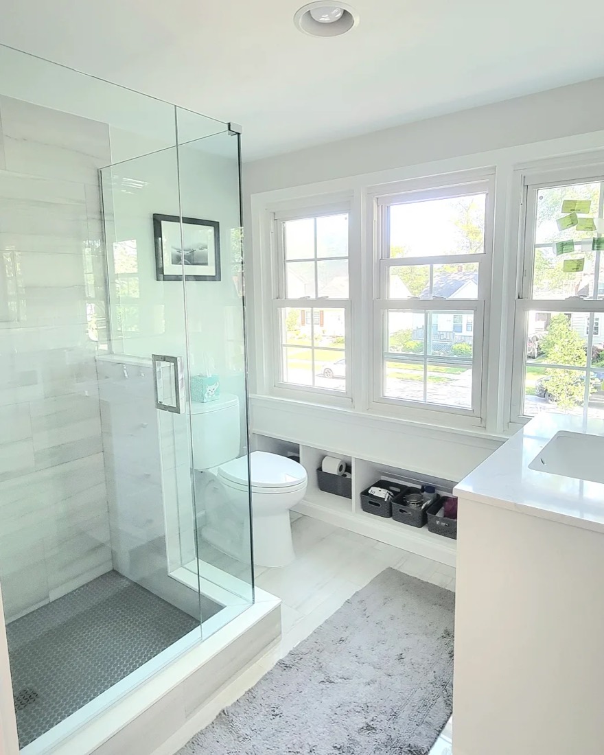 Frameless glass shower beside bright windows