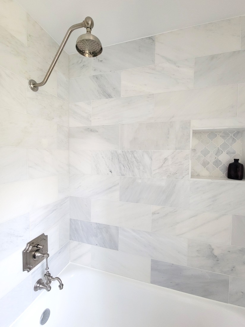 Marble tile shower with brushed nickel rain head