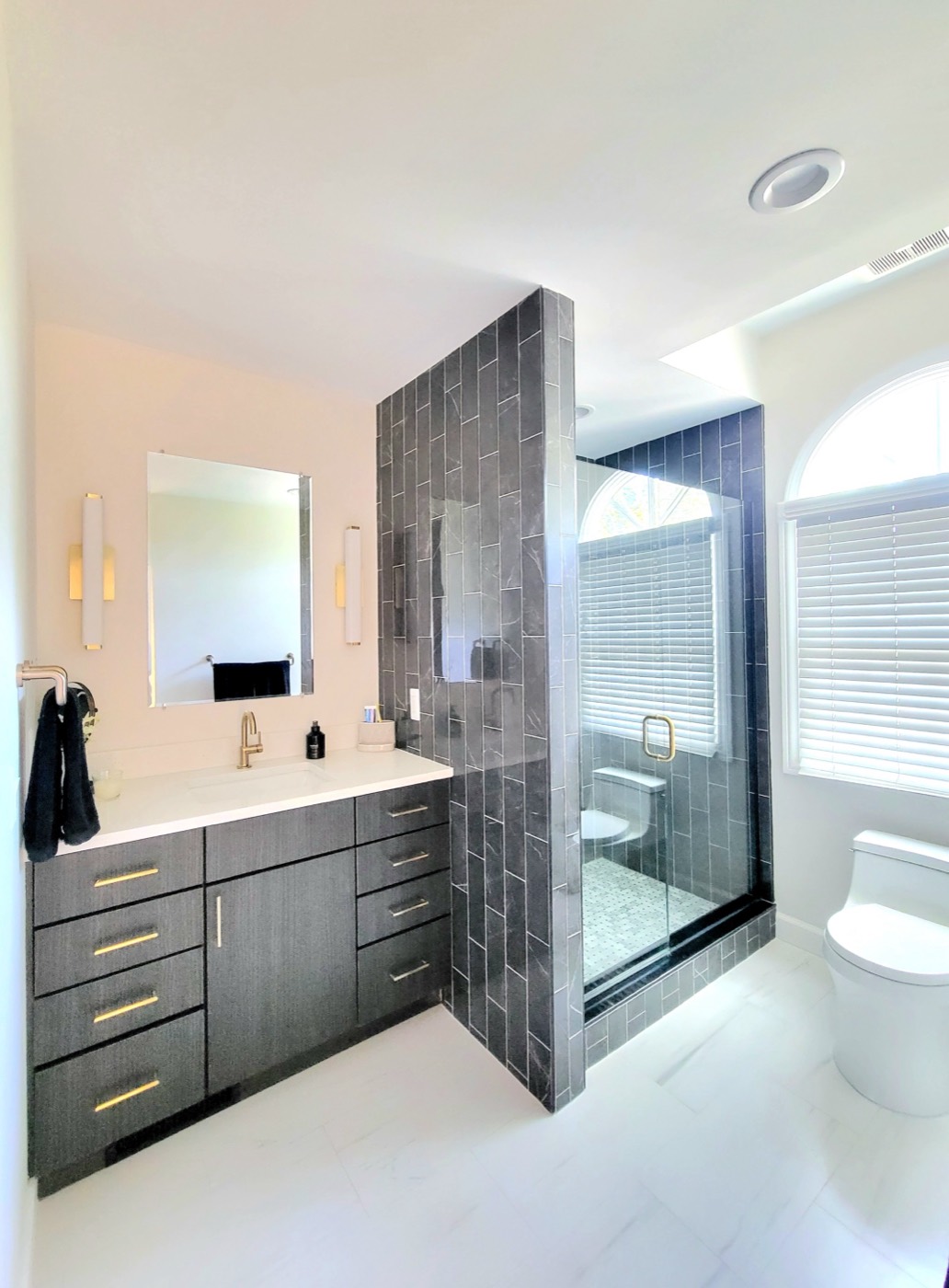 Master bathroom with dramatic dark tile shower wall