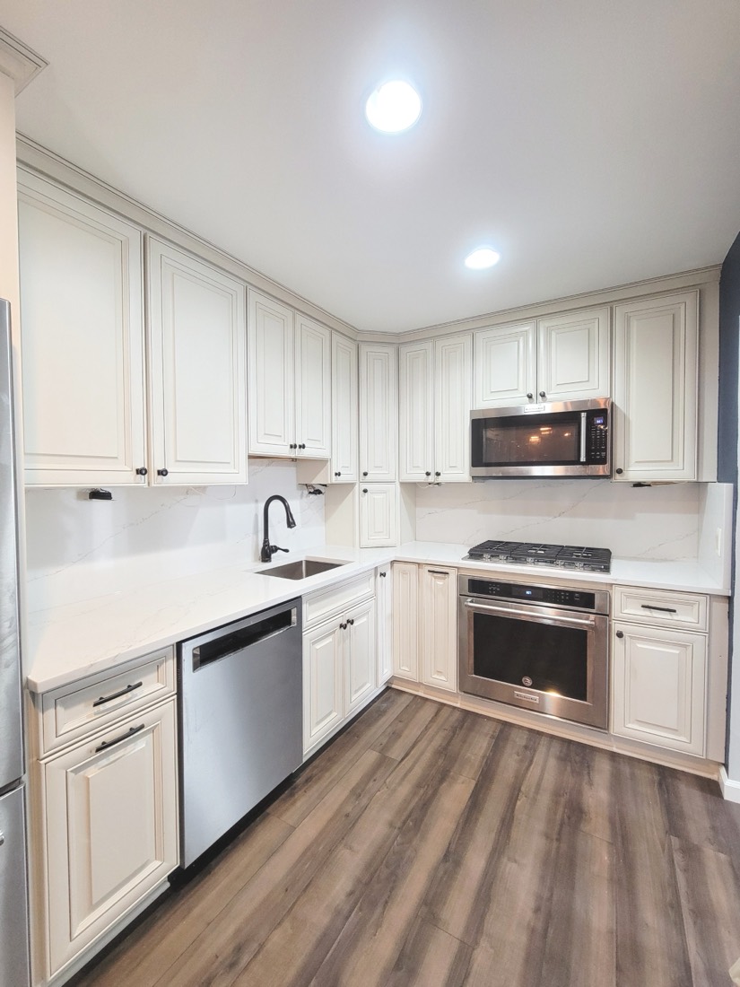 Cream L-shaped kitchen with dark wood floors