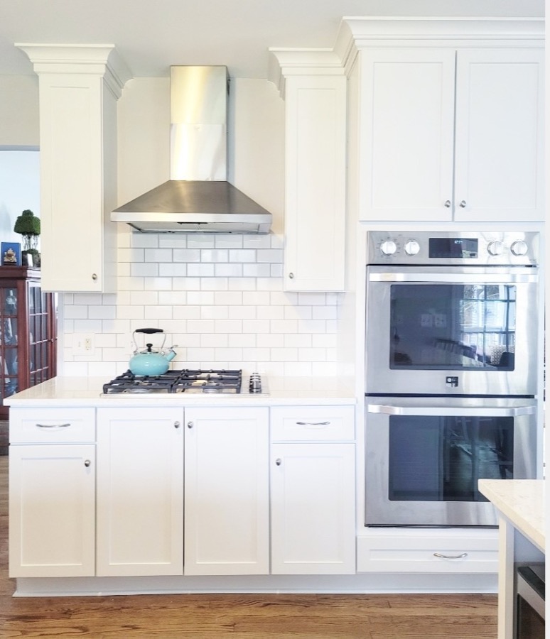 White kitchen with stainless double wall ovens