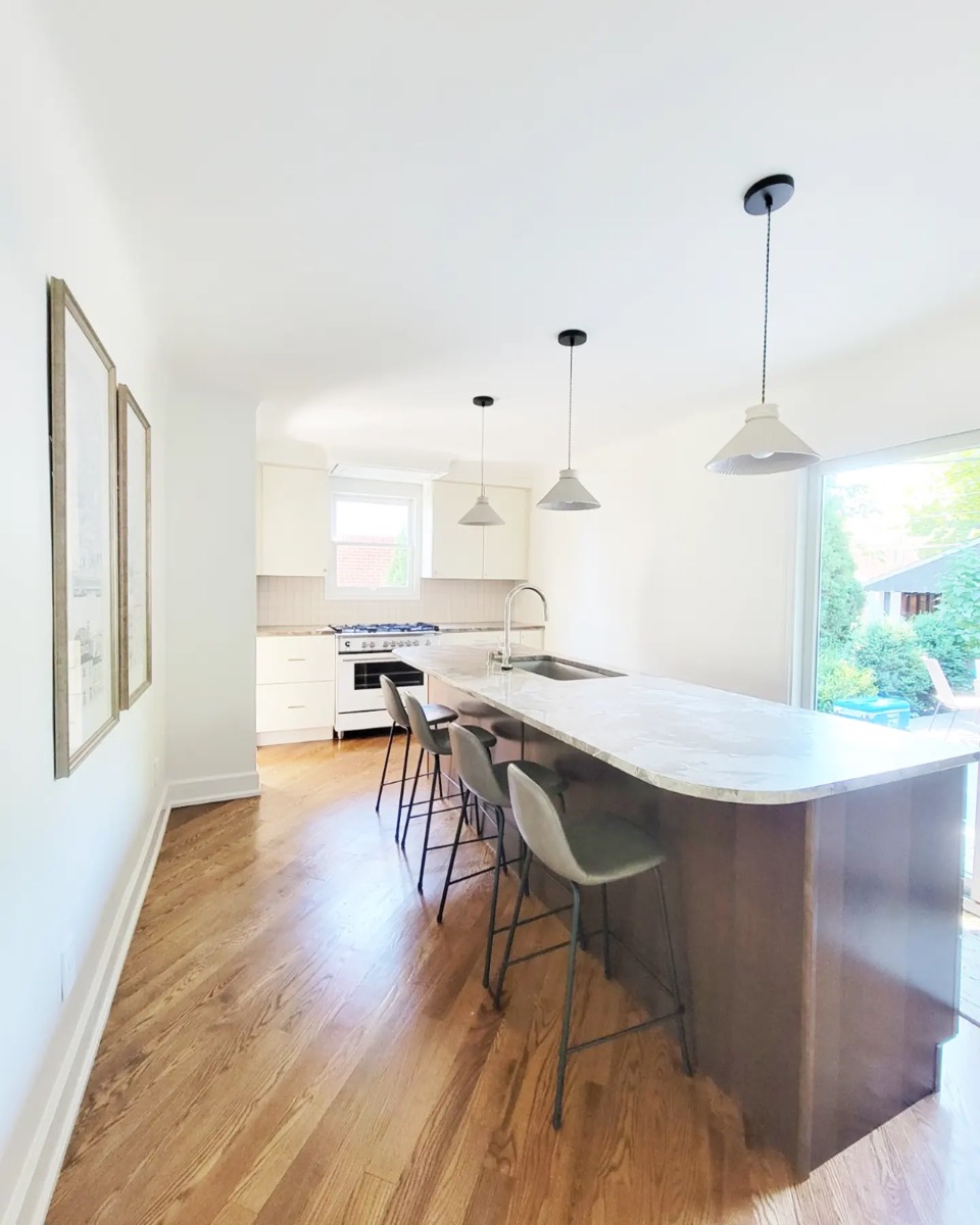 Sunlit kitchen with long marble island