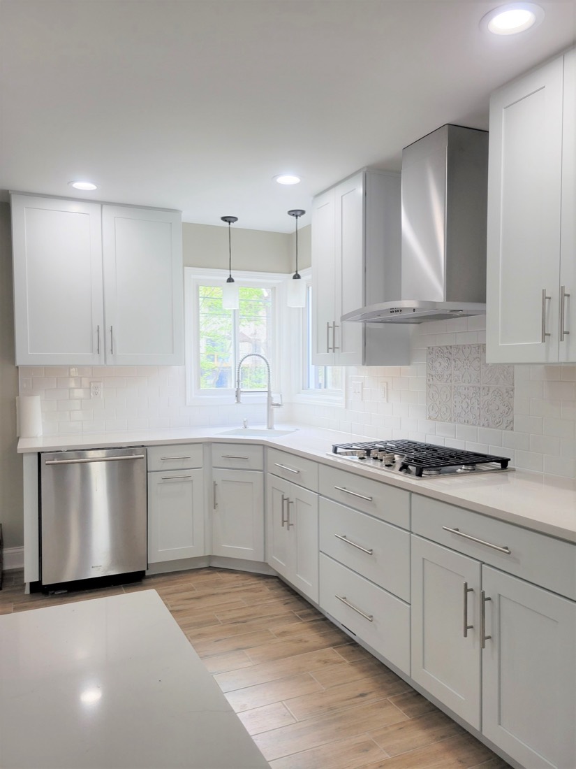 White kitchen with stainless hood and corner windows